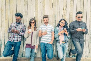 People leaning up against a fence looking at their smart phones. Here are some tips on how to seek and reward quality content. People have the right to encourage quality through conscious choice.